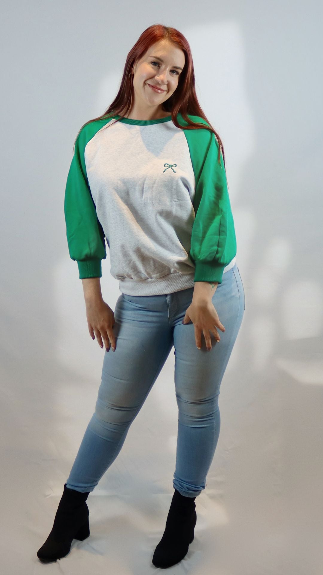 gray and green varsity shirt with bow graphic