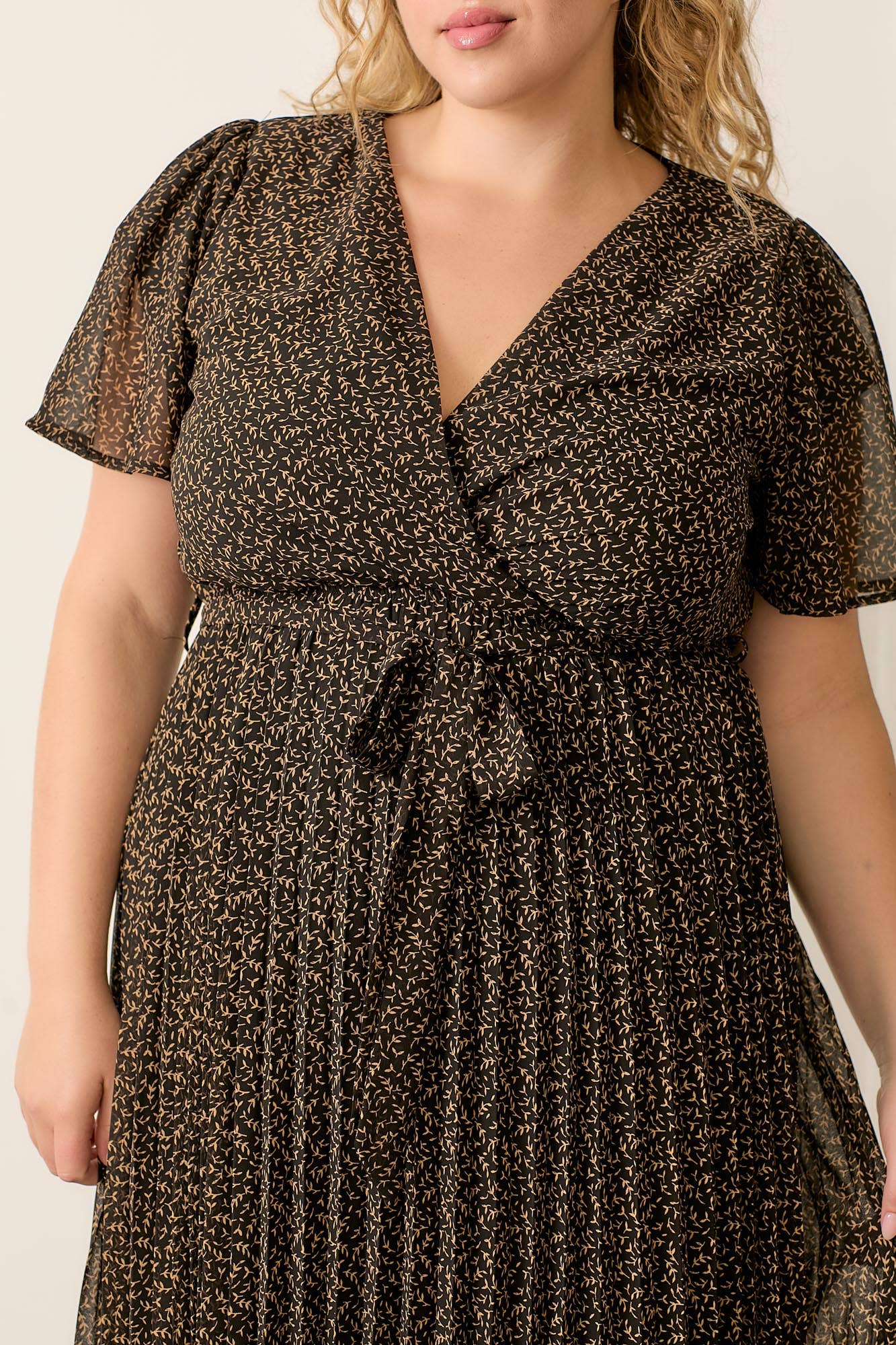 Plus-size dress with surplice neckline and pleated skirt