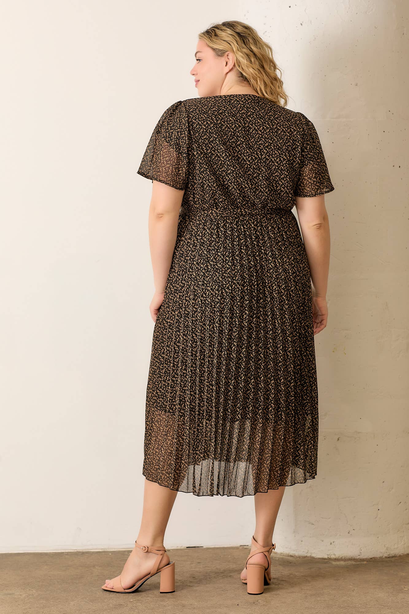 Plus-size dress with surplice neckline and pleated skirt